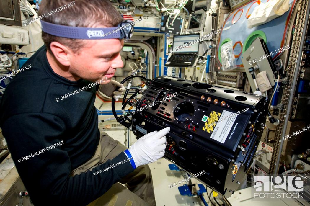 Stock Photo: NASA astronaut Reid Wiseman, Expedition 41 flight engineer, works with the Multi-user Drop Combustion Apparatus (MDCA) in the Destiny laboratory of the.
