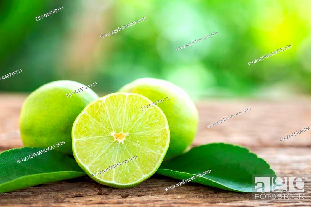 Stock Photo: Close up slice green fresh lemon on wooden table background.
