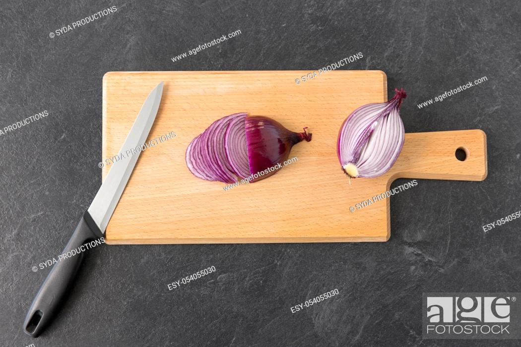 Stock Photo: red onion and kitchen knife on cutting board.