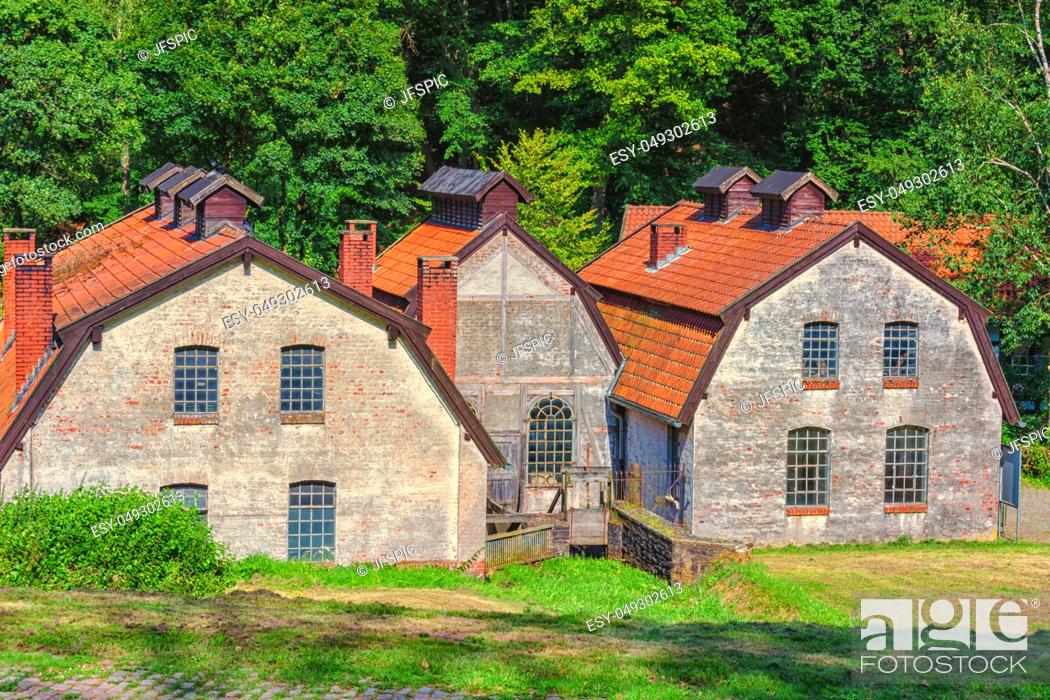 Stock Photo: Large old abandoned factory building of a blacksmith and watermill.