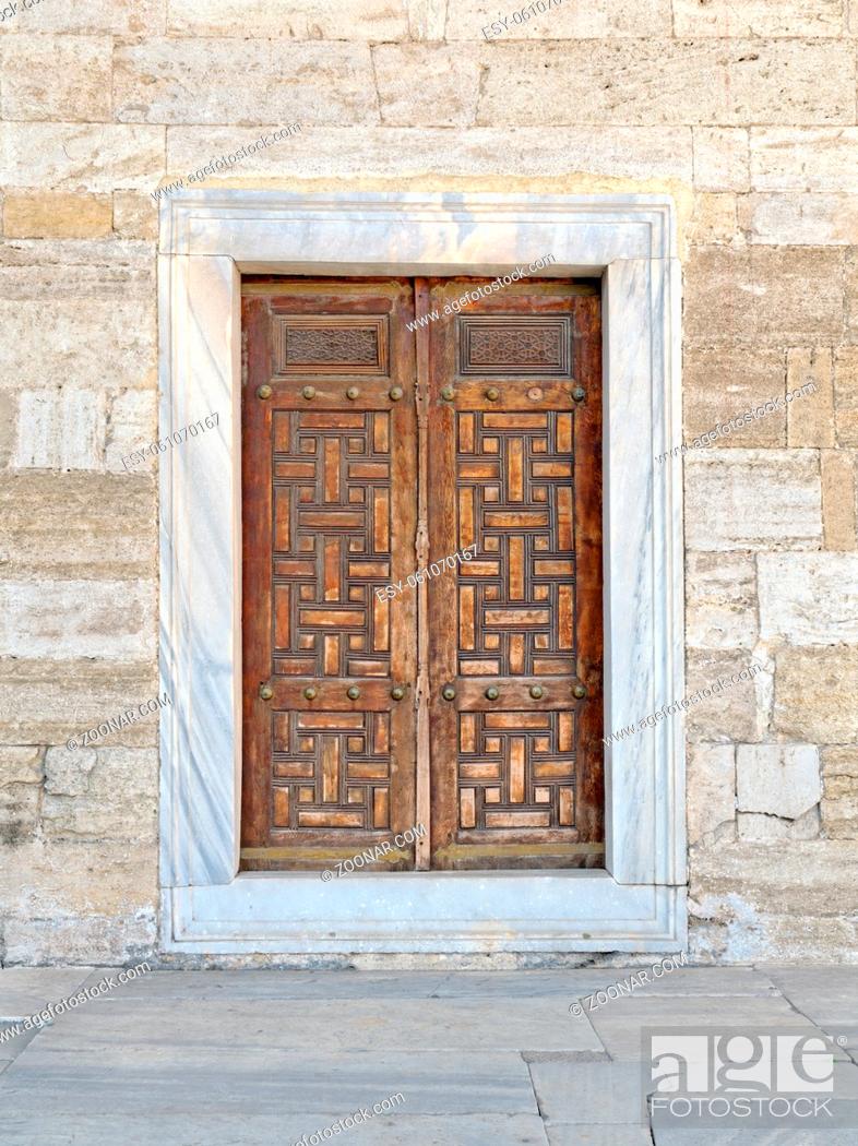 Stock Photo: Wooden aged vaulted engraved door and exterior stone wall, Sultan Ahmet Mosque, Istanbul, Turkey.