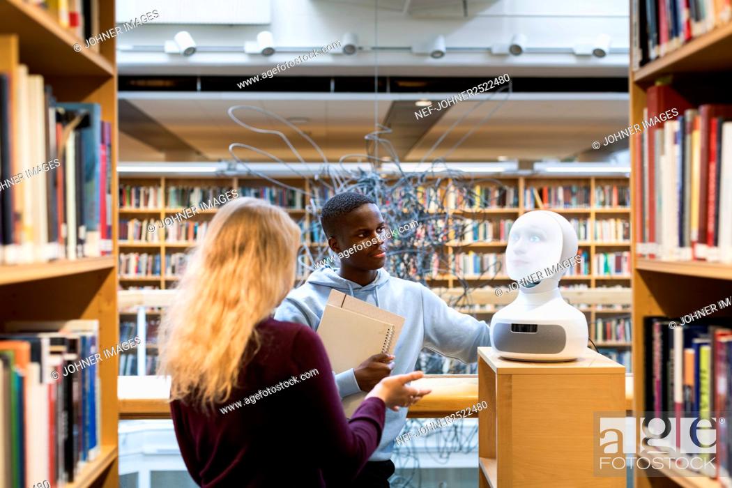 Stock Photo: Students using voice assistant in library.