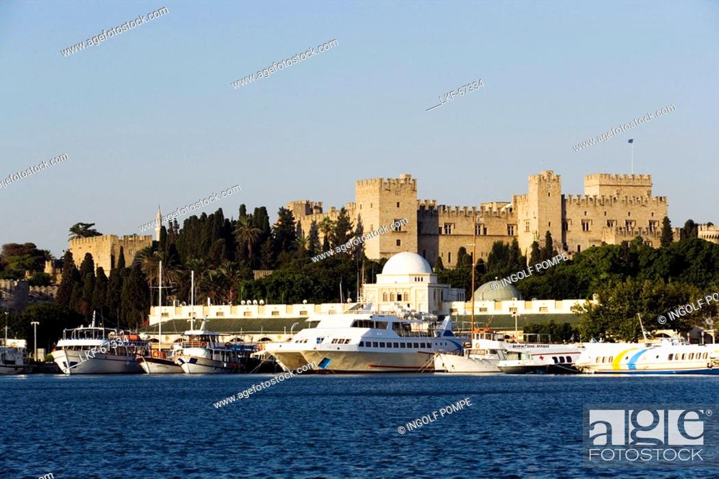 Stock Photo: Ships and boats anchoring in Mandraki harbour translated literally: fold, Palace of the Grand Master and Nea Agora in background, Rhodes Town, Rhodes, Greece.