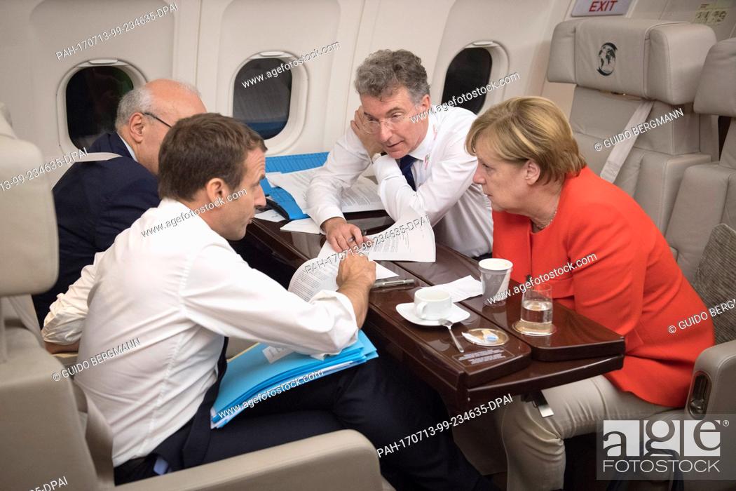 Stock Photo: HANDOUT - Handout picture made available on 12 July 2017 showing German Chancellor Angela Merkel and French President Emmanuel Macron conversing on the way to.