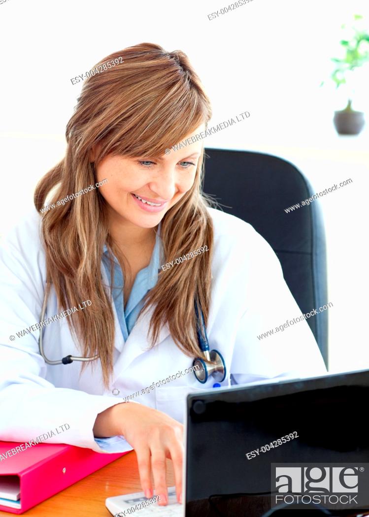 Stock Photo: Smiling female doctor working with a laptop.