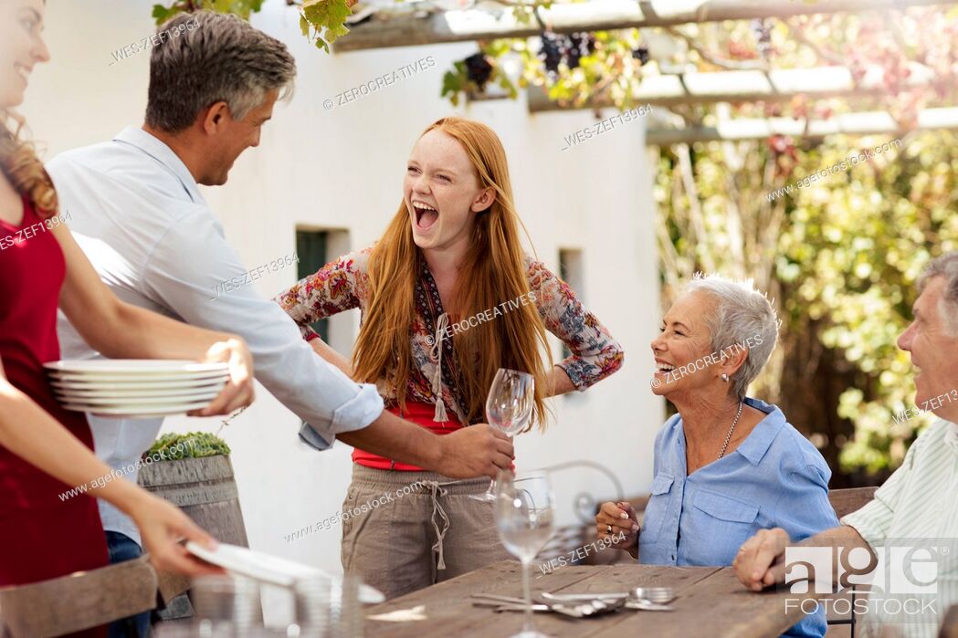 Stock Photo: Happy family setting table outside for lunch.