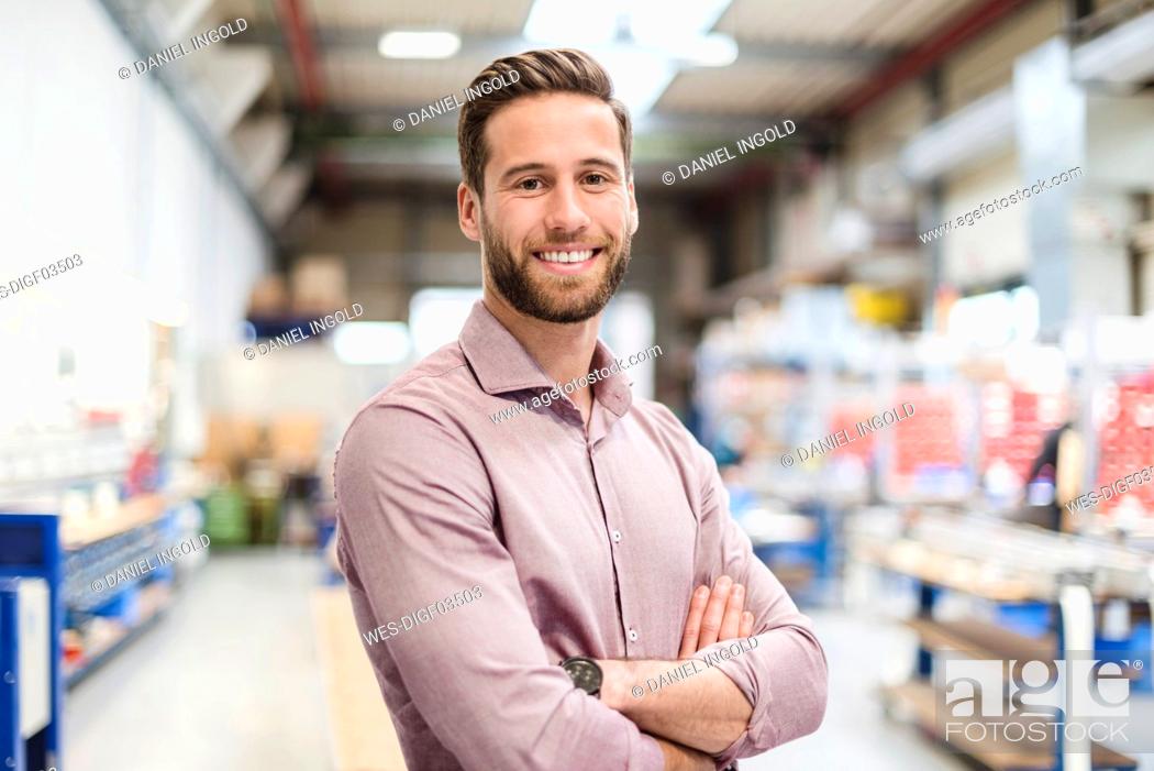 Stock Photo: Smiling businessman in production hall.
