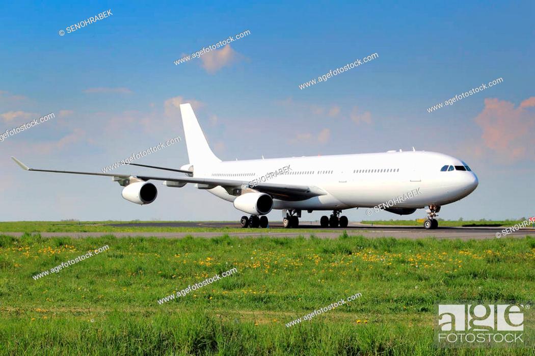 Stock Photo: All white plane taxiing on the airport taxiway.