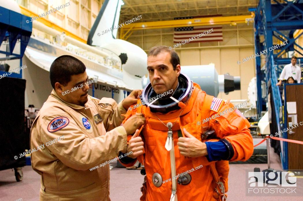 Stock Photo: Astronaut Richard A. (Rick) Mastracchio (right), STS-118 mission specialist, dons a training version of his shuttle launch and entry suit prior to the start of.