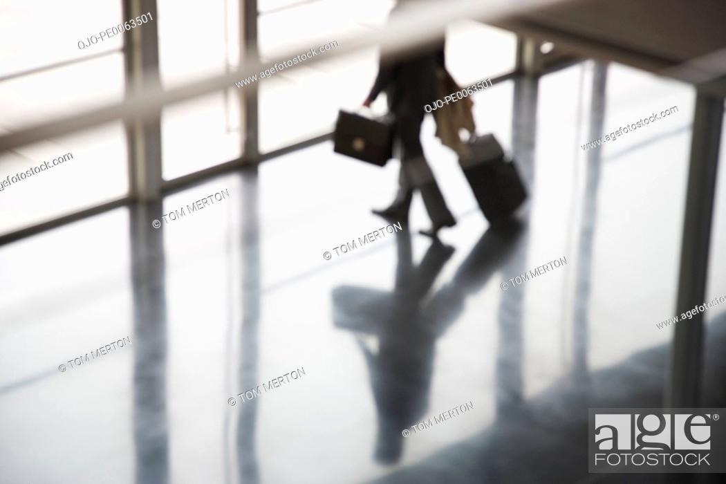 Stock Photo: Businessman leaving building with suitcase.