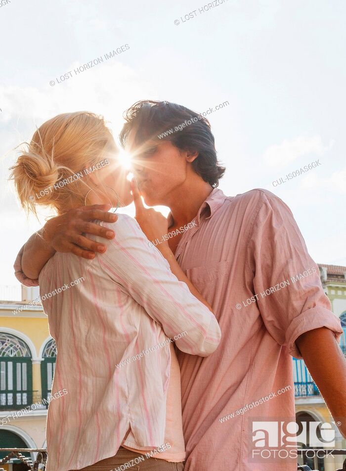 Stock Photo: Romantic young couple kissing on restaurant balcony in Plaza Vieja, Havana, Cuba.
