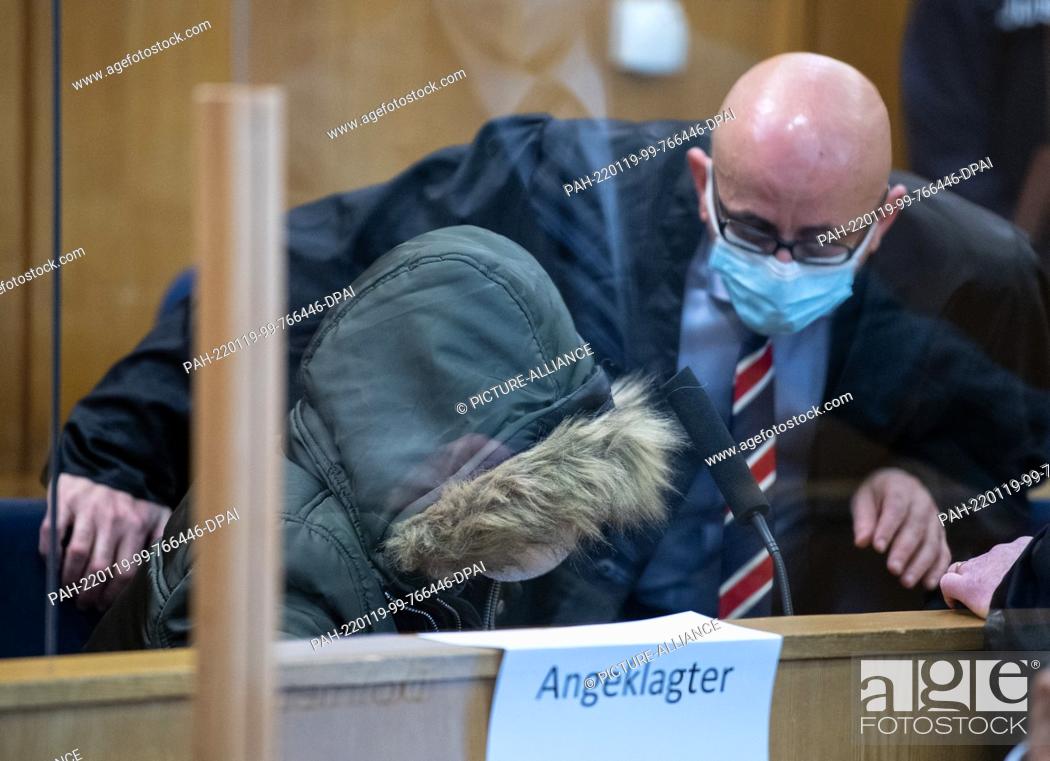 Stock Photo: 19 January 2022, Hessen, Frankfurt/Main: The accused doctor (l, front), who comes from Syria, sits in the security room of the Higher Regional Court in.