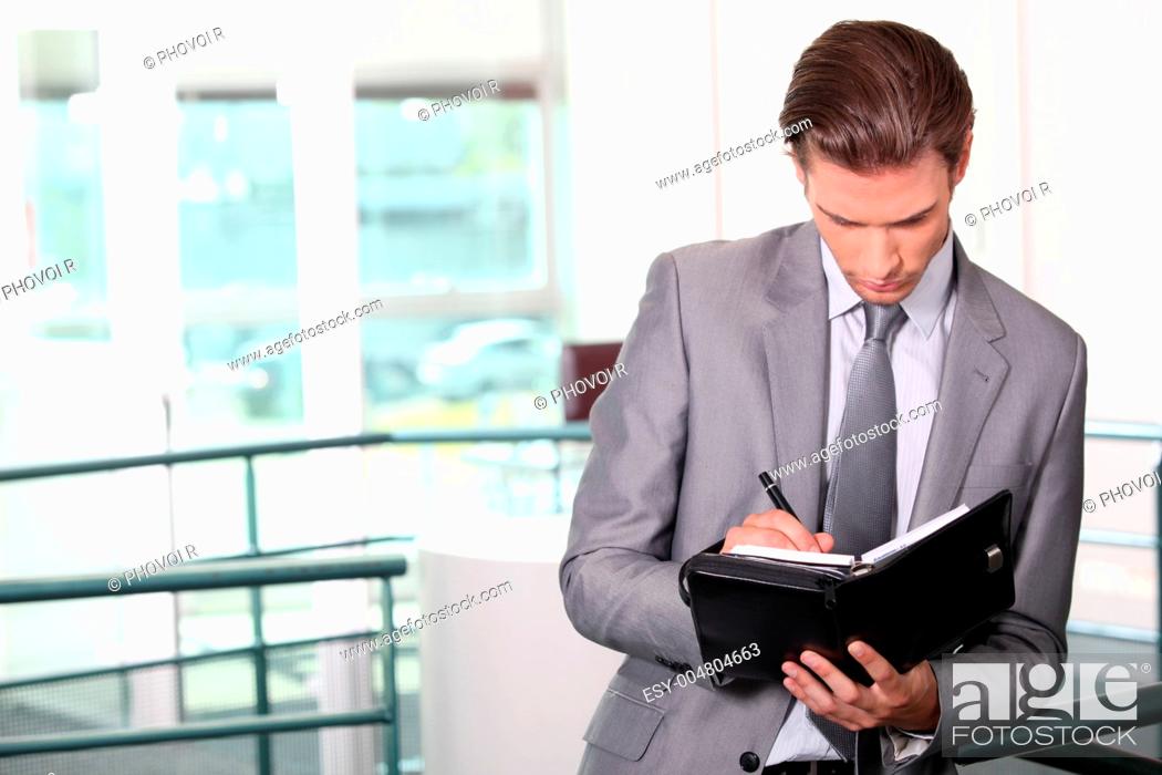 Stock Photo: Businessman writing in diary.