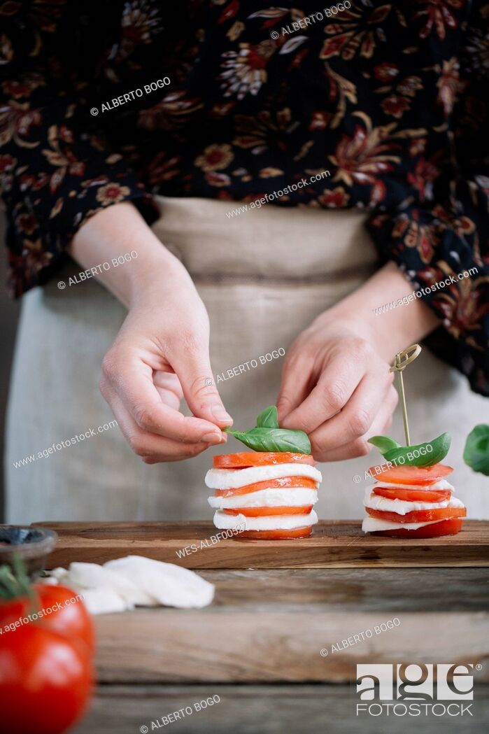 Stock Photo: Woman's hands preparing Caprese Salad.