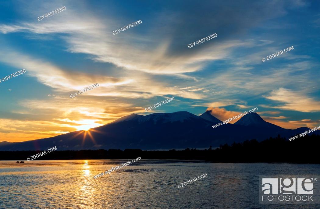 Imagen: Beautiful sunrise over the volcanoes Kluchevskaya group with reflection in the river Kamchatka.