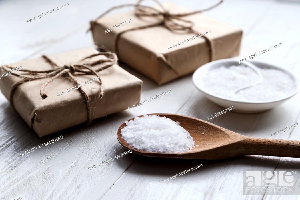 Stock Photo: sea salt on wooden background with gift boxes.