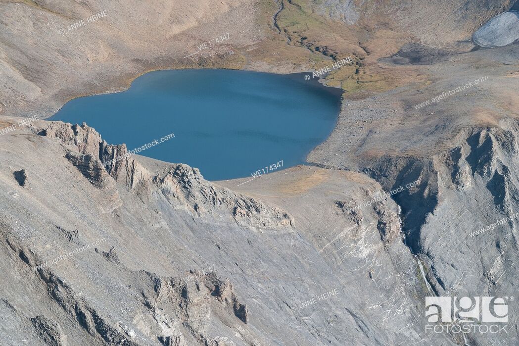 Photo de stock: Tarn (Glacial lake) in rugged terrain above treeline. Taken from the canadian continental divide (Northover Ridge) fromAlberta towards British Columbia.