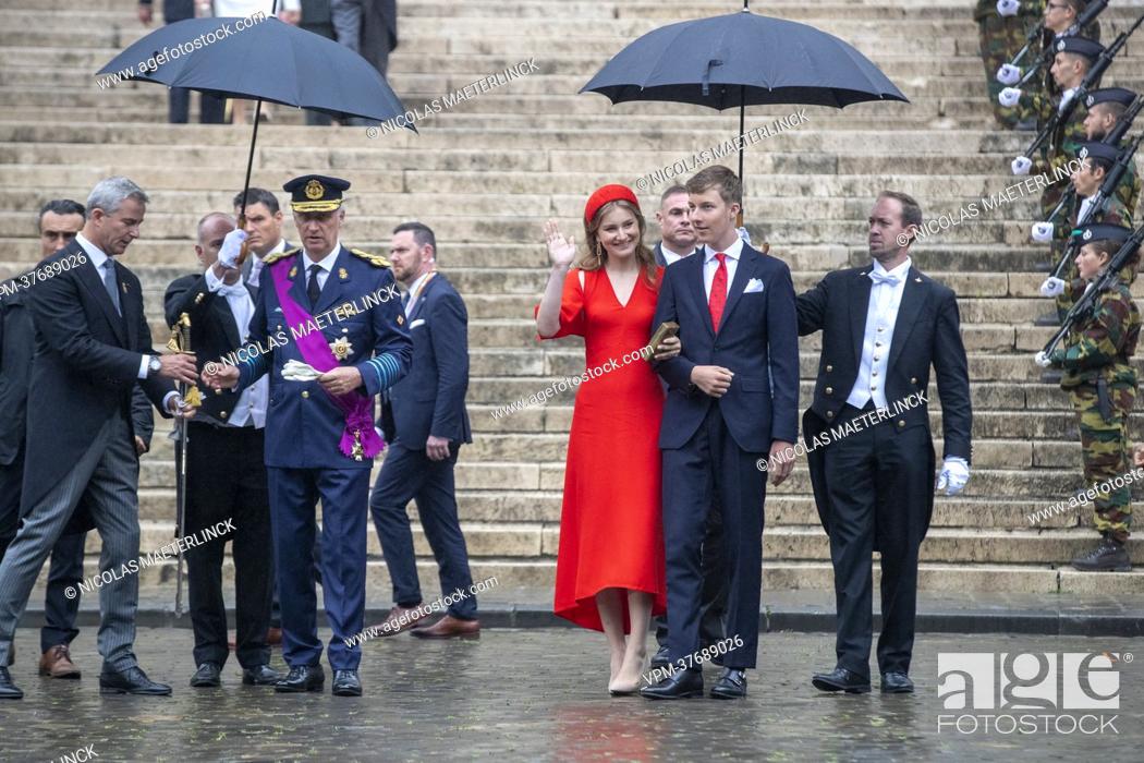 Stock Photo: King Philippe - Filip of Belgium, Crown Princess Elisabeth and Prince Emmanuel are protected by umbrella's as they leave after the Te Deum mass.