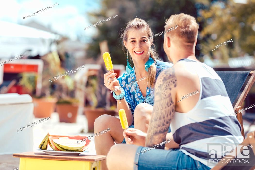 Stock Photo: Happy young couple enjoying popsicles at beach.