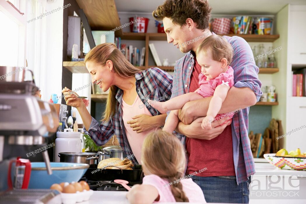 Stock Photo: Family Cooking Meal In Kitchen Together.