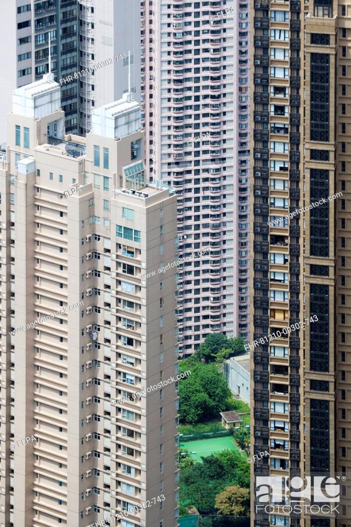 Stock Photo: View of small garden and tennis court amongst skyscraper apartment blocks in densely populated area of city, Hong Kong, China.