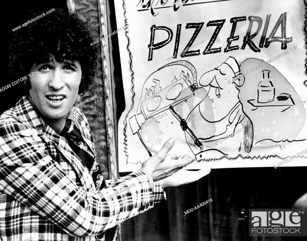 Stock Photo: Ninetto Davoli showing the sign of a pizzeria. Italian actor Ninetto Davoli showing the sign of a pizzeria. Rome, 1974.