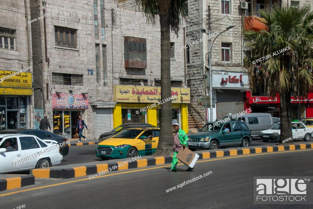 16 October 2018, A waste disposal worker from Amman walks across a street with a..., Foto de Stock, Imagen Protegidos Pic. PAH-200113-99-452576-DPAI | agefotostock