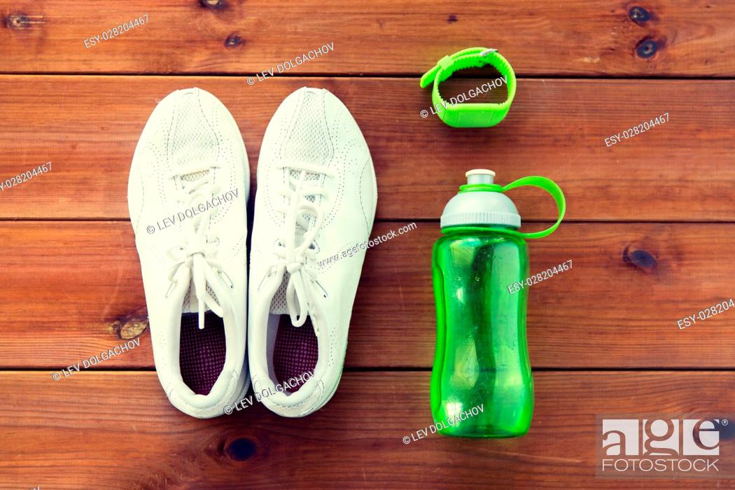Stock Photo: sport, fitness, healthy lifestyle and objects concept - close up of sneakers, bracelet and water bottle on wooden floor.