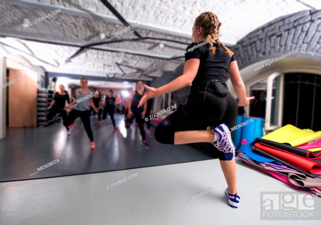 Stock Photo: group of young healthy sporty women working out with instructor doing aerobics exercises in a fitness studio fitness, sport, training, gym and lifestyle concept.