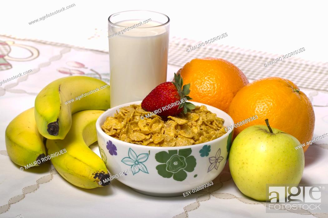 Stock Photo: View of a bowl of cereals surrounded by fruit and a glass of milk.