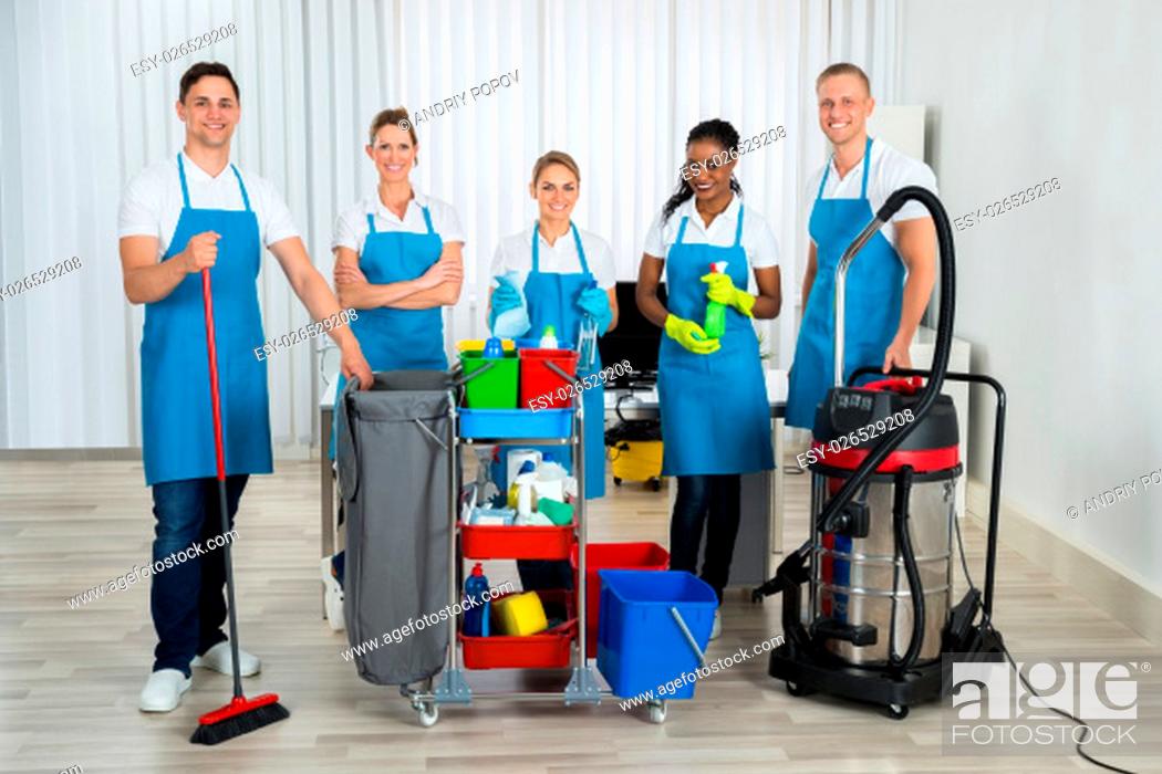 Stock Photo: Group Of Happy Cleaners Standing With Cleaning Equipments In Office.