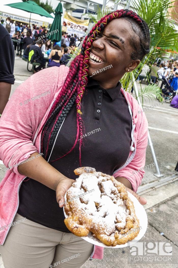 Imagen: Florida, Miami, Miami-Dade College, Book Fair, annual event, Black, teen, girl, braided hair weave, dyed red, funnel cake, fashion fashionable,.