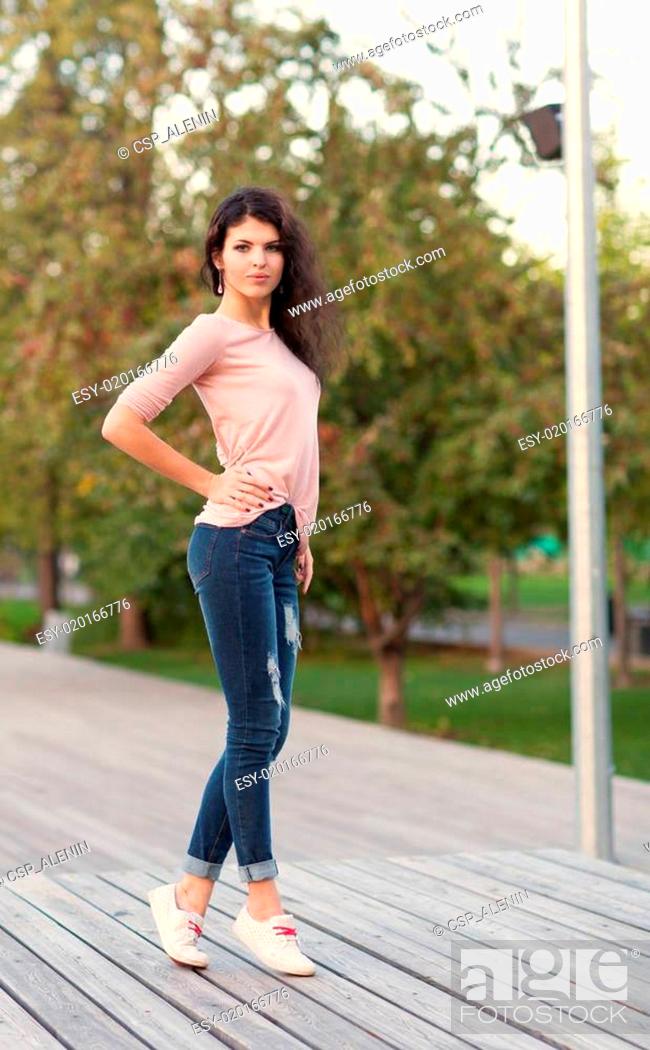 Beautiful tall girl with long hair brunette in jeans standing on old wooden  planks on a warm summer..., Stock Photo, Picture And Low Budget Royalty  Free Image. Pic. ESY-020166776 | agefotostock
