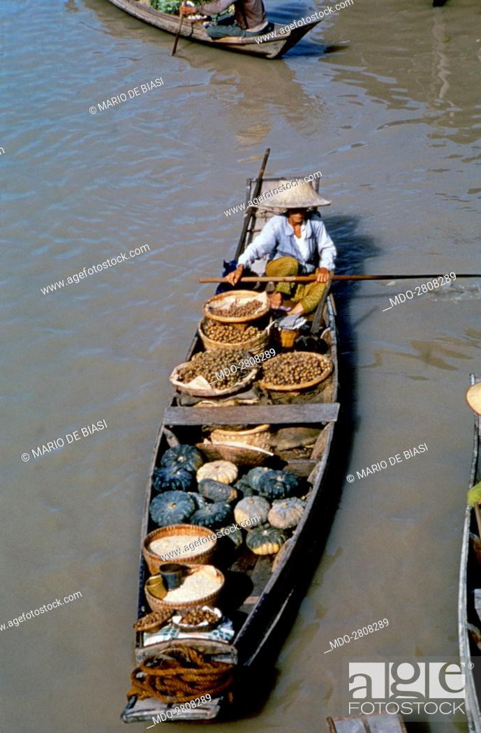 Stock Photo: Pirogue full of fruits and greens sailing the river Chao Phraya. Bangkok, 1961.