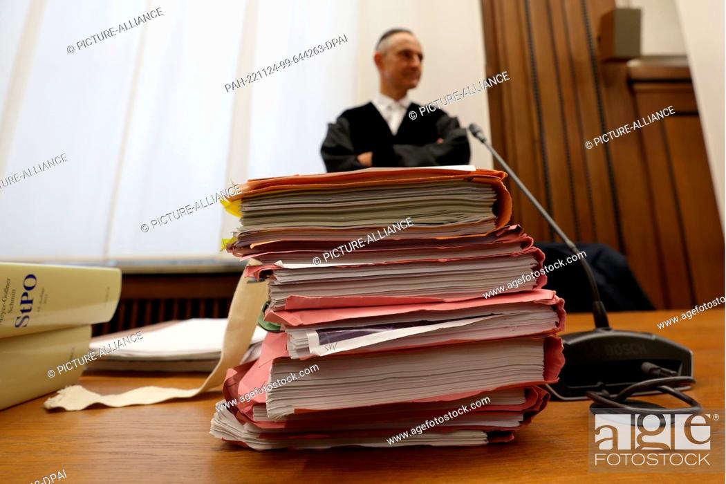 Stock Photo: 24 November 2022, North Rhine-Westphalia, Mönchengladbach: Prosecutor Stefan Lingens stands behind a stack of court files lying on a table in the regional court.