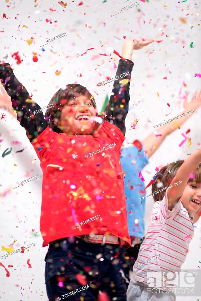 Photo de stock: Happy kids celebrating party with blowing confetti.