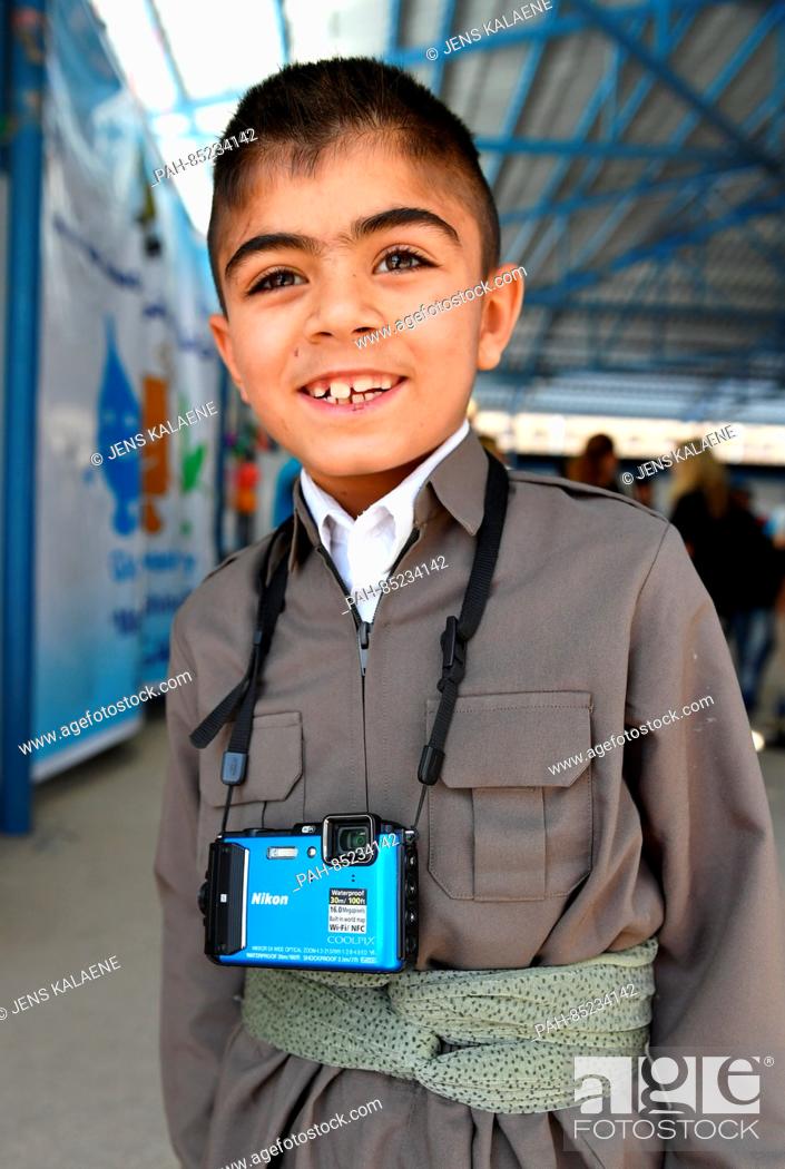 Stock Photo: Nine-year-old Murat stands with a camera in a refugee camp in Aqrah, Iraq, 19 October 2016. Murat has received a small camera from UNICEF he uses to photograph.