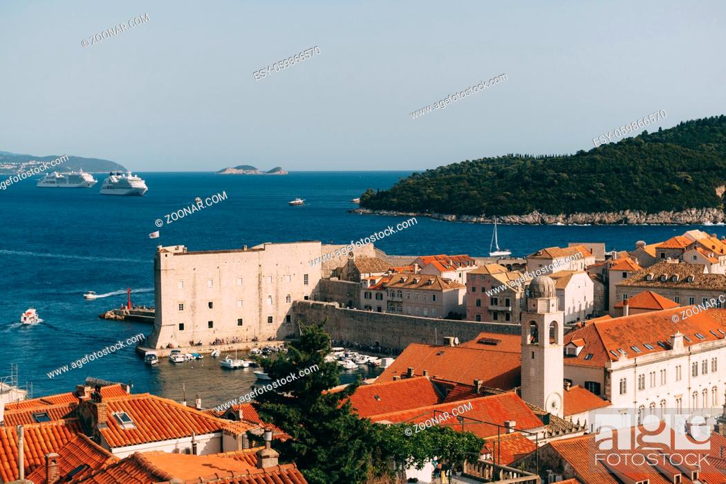 Stock Photo: View of the fort on the wall, Lokrum island and moored boats near the city walls. The old port harbor is porporela, near the walls of the old town of Dubrovnik.