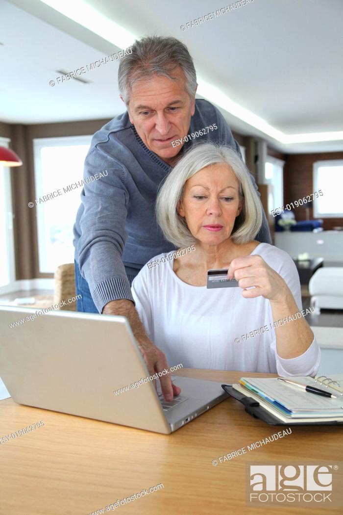 Stock Photo: Senior couple making secured payment on internet.