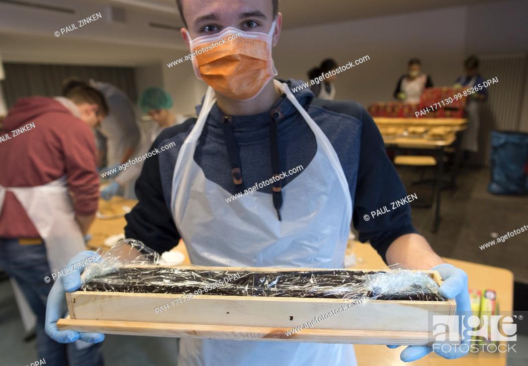 Stock Photo: Vladislaw, a student at the Philipp Reis School in Berlin's Lichtenberg, helping in the production of a giant hedgehog slice in Berlin, Germany.