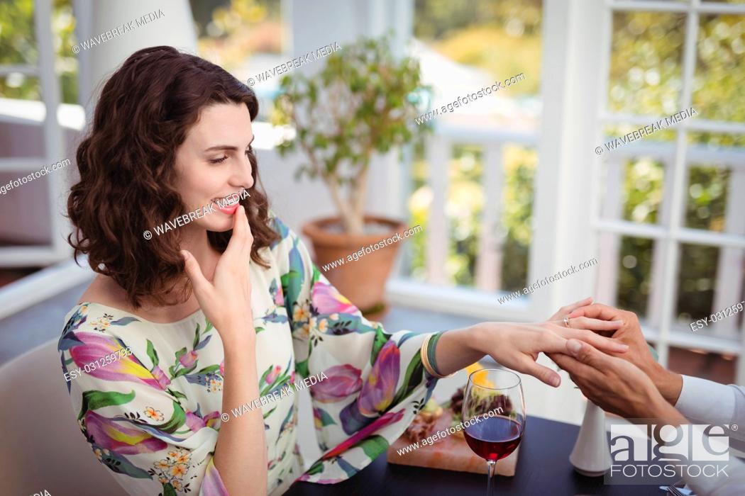 Stock Photo: Man putting engagement ring on woman hand.