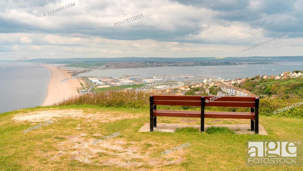 Stock Photo: A bench on the South West Coast Path with view towards Fortuneswell and Chesil Beach, Isle of Portland, Jurassic Coast, Dorset.