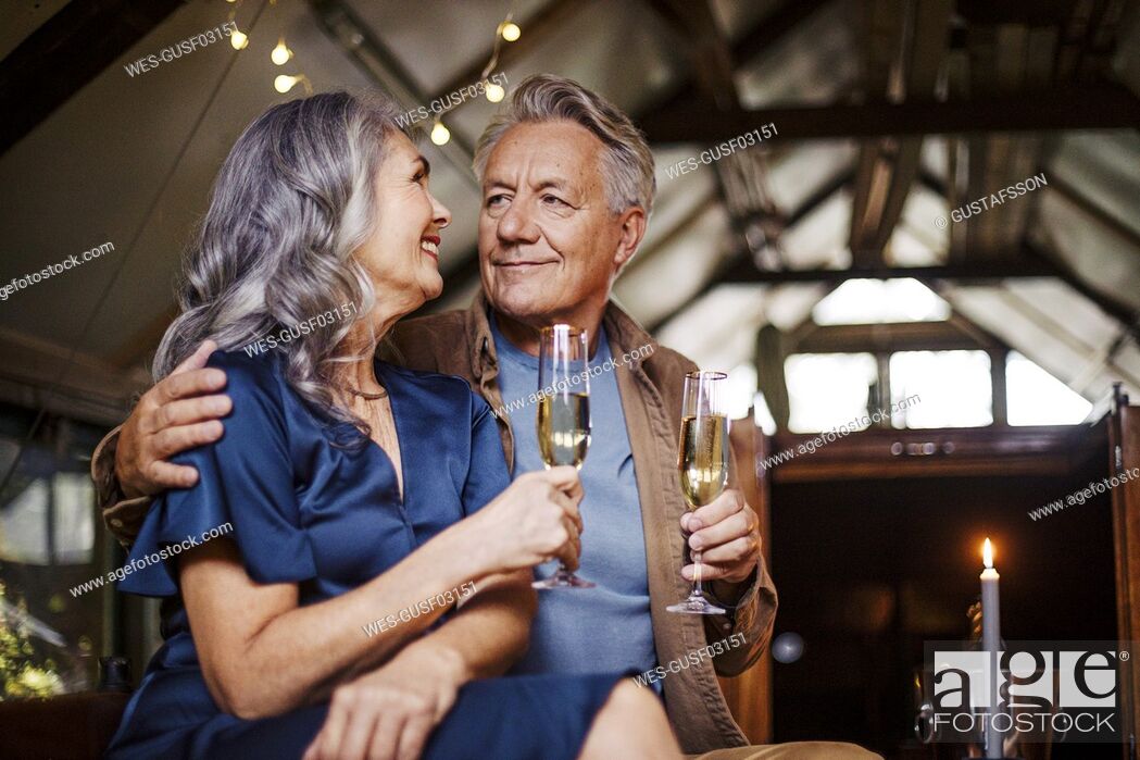 Stock Photo: Senior couple having a candlelight dinner on a boat in boathouse.