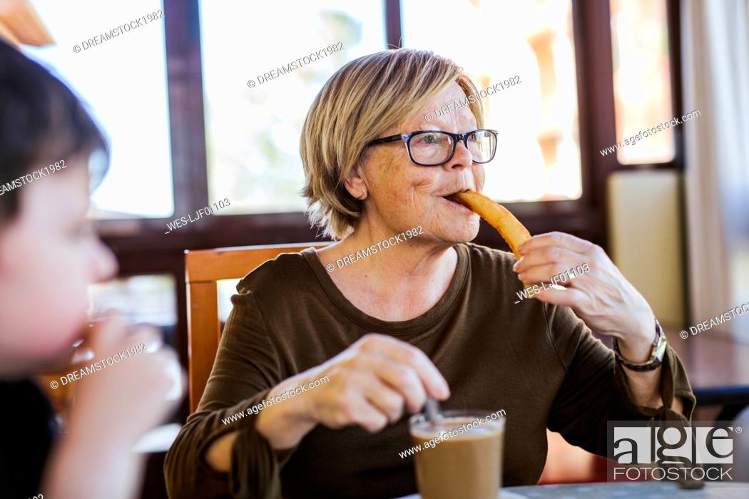 Stock Photo: Grandmother and grandson having breakfast at table at home together.