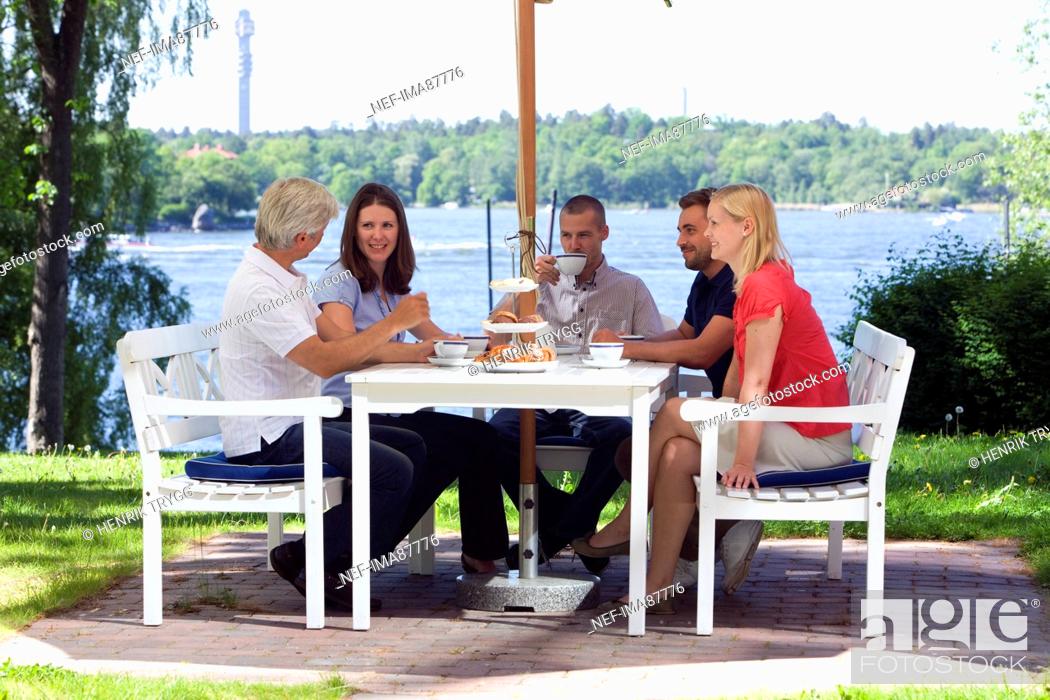 Stock Photo: Six people having coffee beside sea.