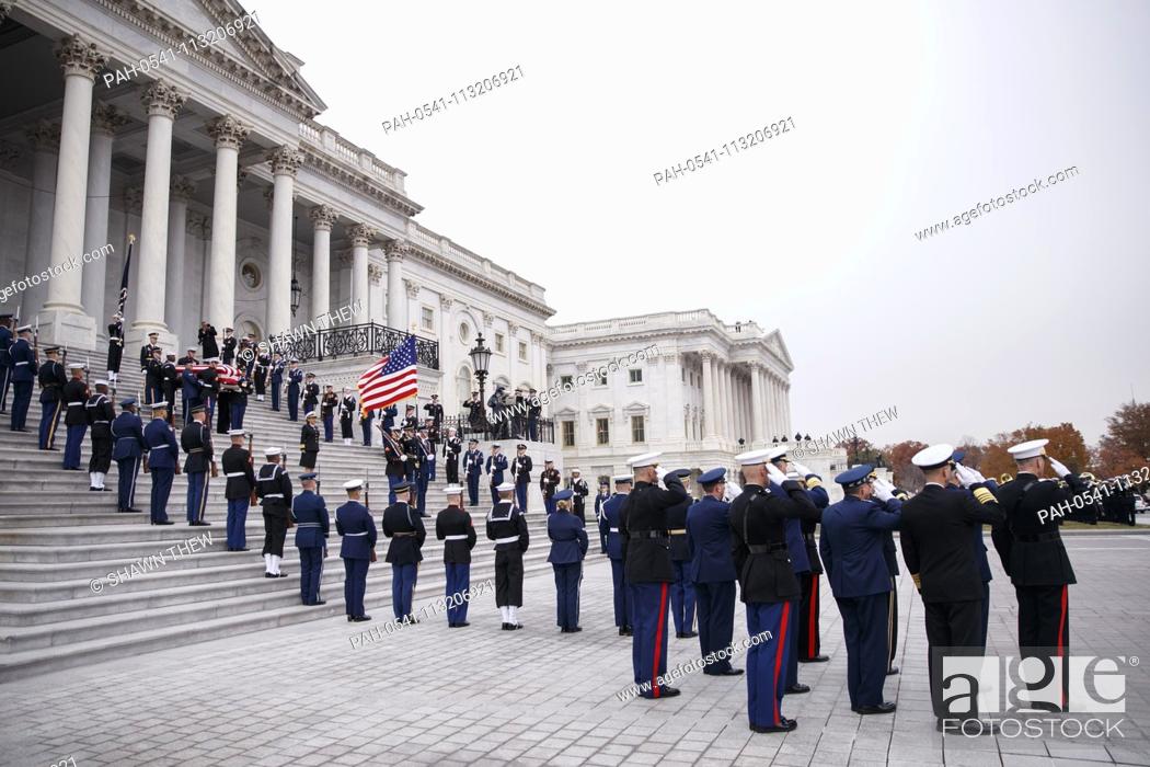 Stock Photo: A joint service honor guard loads the casket of former US President George H.W. Bush into the waiting hearse on the East Front of the US Capitol in Washington.