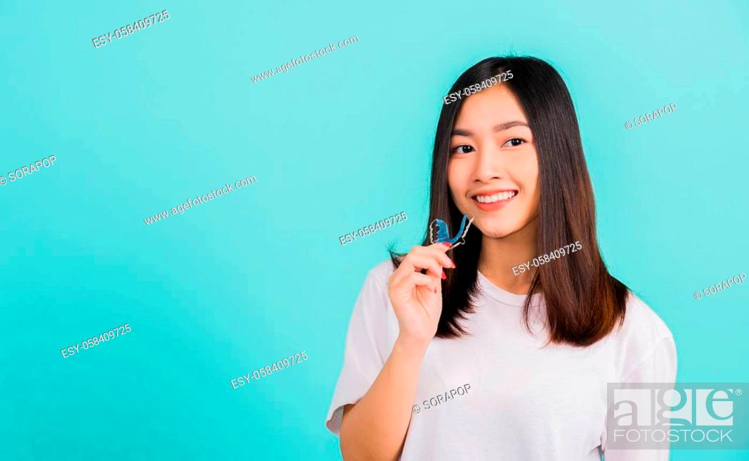 Stock Photo: Portrait young Asian beautiful woman smiling holding silicone orthodontic retainers for teeth, Teeth retaining tools after removable braces.