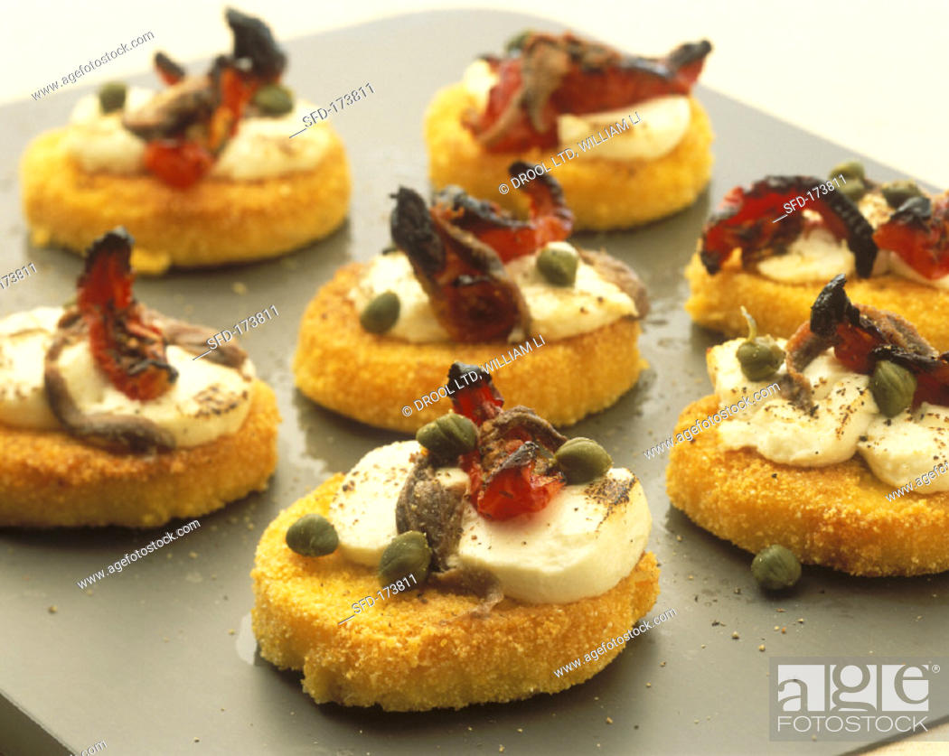 Stock Photo: Polenta-Parmesan snacks with anchovies, capers, sheep cheese (1.