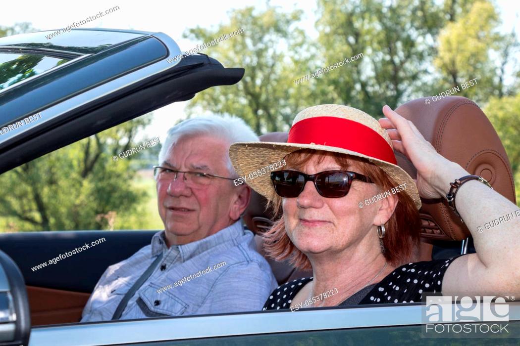 Stock Photo: Older couple in a luxury convertible car on a sunny day.