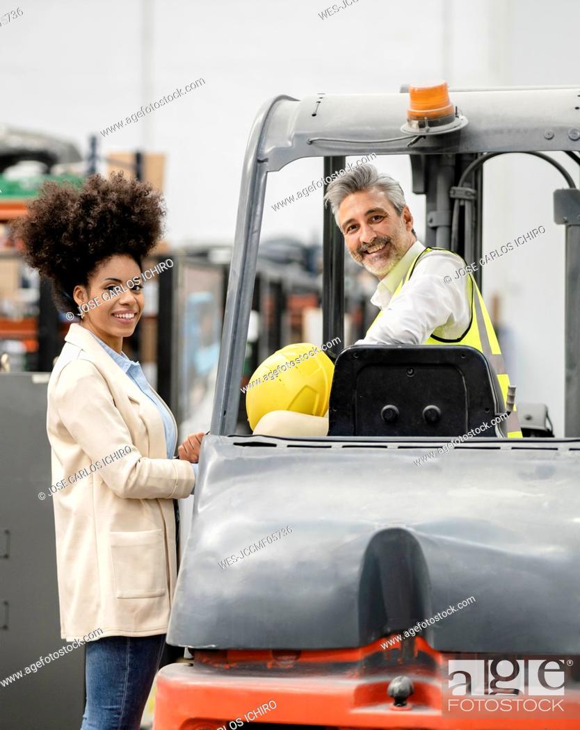 Photo de stock: Smiling businesswoman with engineer in warehouse at factory.